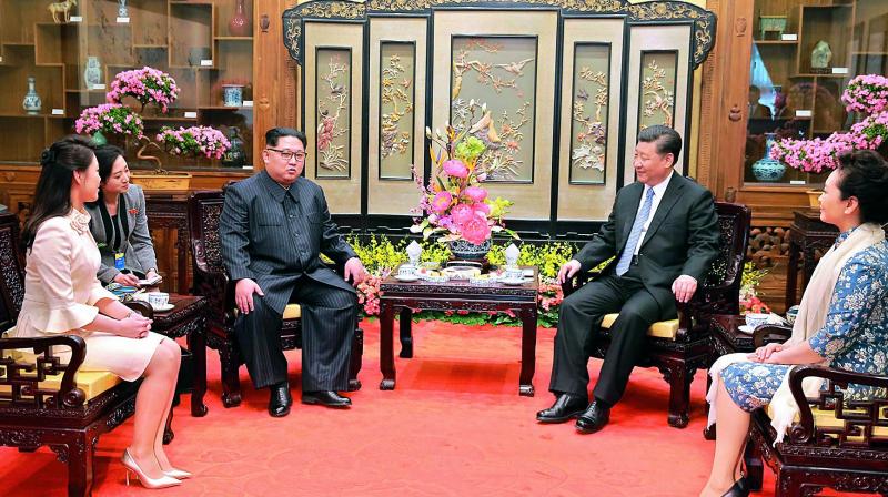 North Korean leader Kim Jong Un, center left, and his wife Ri Sol Ju, left, talk with Chinese counterpart Xi Jinping, second from right, and his wife Peng Liyuan at Diaoyutai State Guesthouse in Beijing. 	w(Photo:AFP)