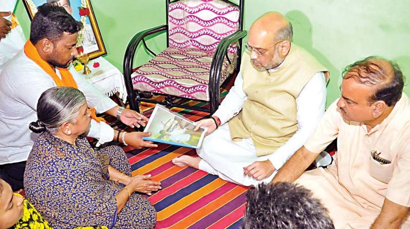 Amit ShahBJP president Amit Shah, visits the kin of Raju, a RSS worker, who was killed in a clash in 2016, at Kyathamaranahalli, on Friday (Photo:DC)
