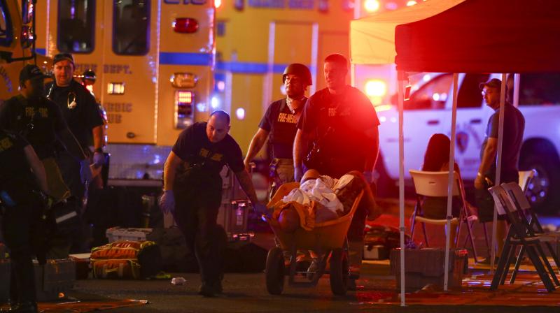 A wounded person is walked in on a wheelbarrow as Las Vegas police respond during an active shooter situation on the Las Vegas Stirp in Las Vegas Sunday. (Photo: AP)
