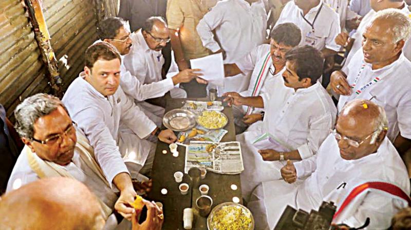 Congress president Rahul Gandhi, CM Siddaramaiah and party leaders have mirchi bajji, a local pakoda snack, along with tea at Kalamala, near Raichur on Monday.