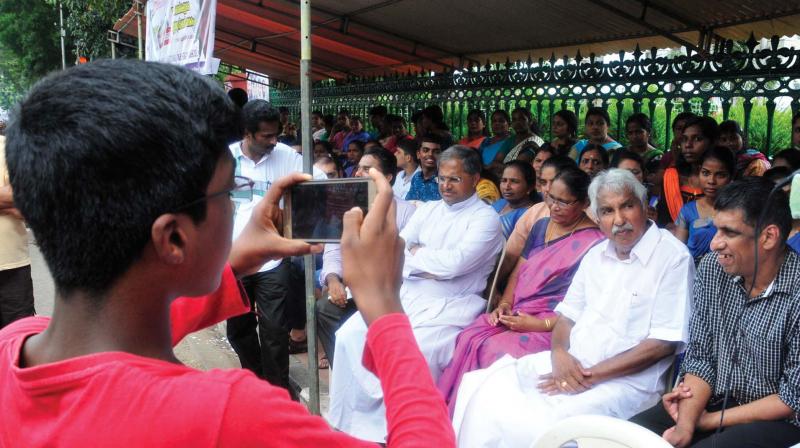 A special student takes picture of former Chief Minister Oommen Chandy who sat in solidarity with the special needs students, parents and teachers who observed a 12-hour fast in front of the secretariat in Thiruvananthapuram on Tuesday demanding aided category to 33 special schools. (Photo: A.V. MUZAFAR)