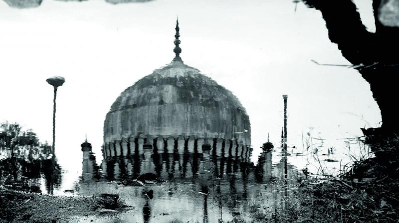 Reflection of one of the Qutb Shahi tombs post rains in a puddle of muddy rain water.