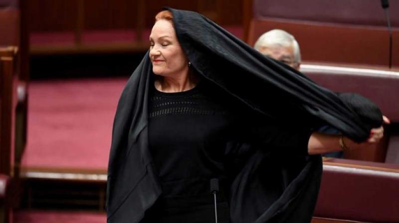Pauline Hanson, leader of the anti-Muslim, anti-immigration One Nation minor party, sat wearing the black head-to-ankle garment for more than 10 minutes before taking it off as she rose to explain that she wanted such outfits banned on national security grounds. (Photo: Twitter)