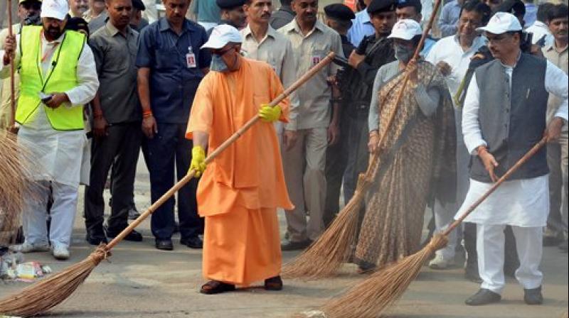 UP Chief Minister Yogi Adityanath weilds a broom as he takes part in a cleanliness drive at the western gate of the Taj Mahal in Agra on Thursday. Dy Chief Minister Dinesh Sharma and Tourism Minister Rita Bahuguna are also seen. (Photo: PTI)