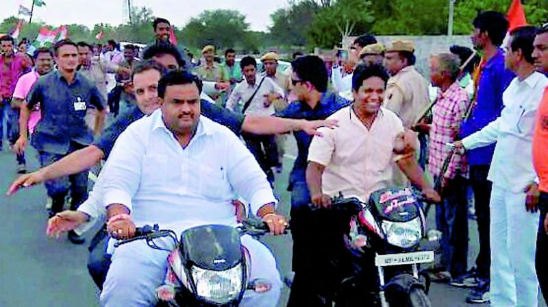 Congress vice-president Rahul Gandhi rides pillion on a bike on his way to Madhya Pradeshs Mandsaur on Thursday. He uncharacteristically swapped his car for a bike, then hopped on to another bike, and finally set out on foot through fields before he was detained. (Photo: PTI)