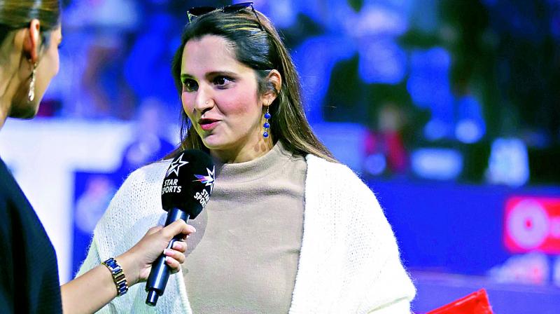 Sania Mirza holds the Hyderabad Hunters flag as she roots for her home team in their PBL Season 4 match against Delhi Smashers in Bengaluru on Wednesday.