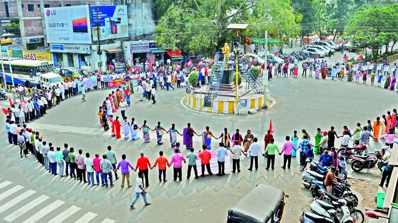 BSNL and bank employees with trade union leaders form a human chain during a protest as part of nationwide general strike against the alleged anti-worker policies of the government, at Ambedkar circle in Rajahmundry on Wednesday. (Photo: DC)