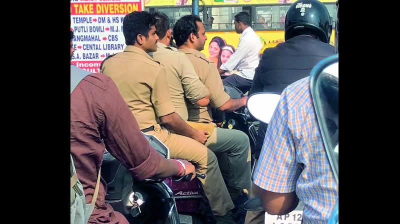 Cops were seen triple riding without wearing helmet on Monday. (Photo: DC)