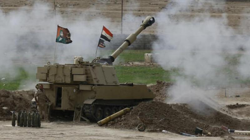 Iraqi soldiers fire a shell from a tank in the Iraqi village of Ali Rash toward Mosul in the fight against Islamic State militants. (Photo: AP)