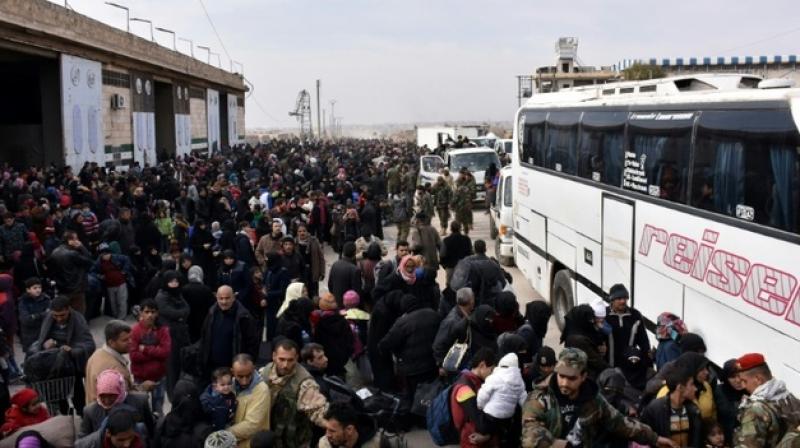 Syrian families, fleeing from various eastern districts of Aleppo, queue to get onto buses. (Photo: AP)