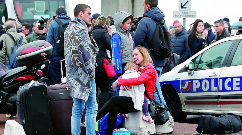 Travelers wait outside the Orly airport