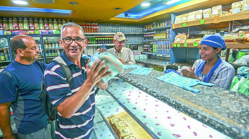 A man smiles after buying a bag of bread in a bakery in Caracas