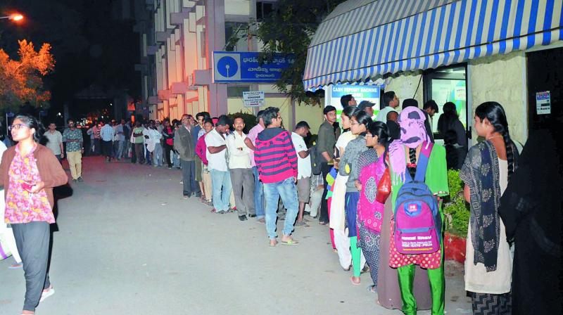 Customers wait for their turn as they queue up outside a State Bank ATM at Bank Street in Koti on Friday. A huge rush was seen as the ATMs in the surrounding areas had run dry of cash. 	(Photo: DC)