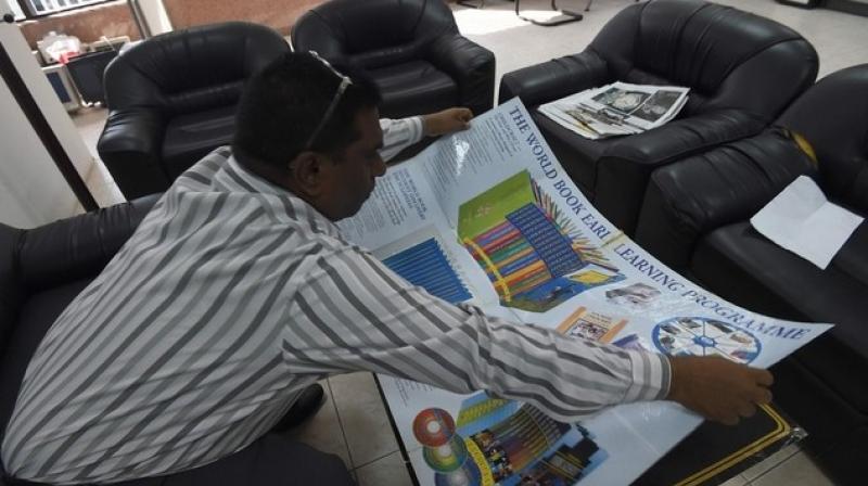 Indian salesman John Gunti displays explaining material about a childrens learning programme he offers for sale, during a demonstration of his sales pitch in the Saudi capital Riyadh. (Photo: AFP)