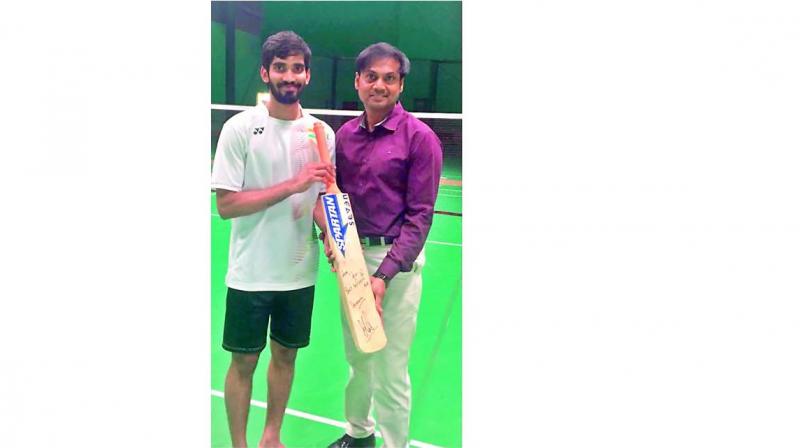 Indian shuttler Kidambi Srikanth (left) poses alongside chairman of national cricket selection committee MSK Prasad with the Mahendra Singh Dhoni-signed bat.