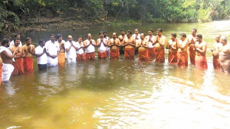 Supporters of AMMK leader T.T.V. Dhinakaran and disqualified AIADMK MLAs offer prayers while taking a dip in the river at the Tamirabharani Maha Pushkaran in Tirunelveli district on Tuesday.	(Photo: DC)