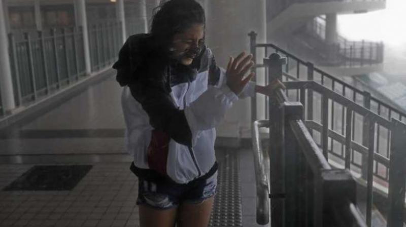 A girl stands against strong wind caused by Typhoon Mangkhut at a pier on the waterfront of Victoria Habour Hong Kong. (Photo: AP)