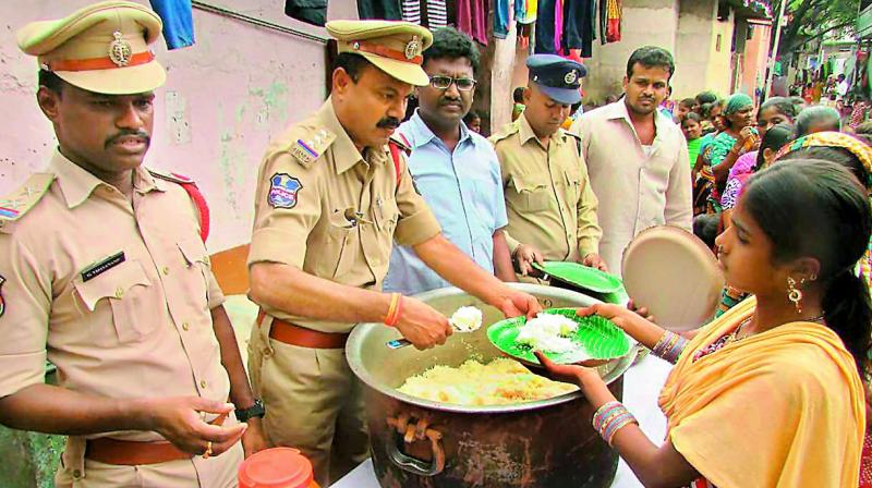 Police personnel organise community lunch in rain-affected areas of the city on Tuesday.