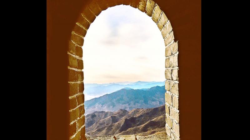 Picturesque delight of looking at a mountain range from the arch of an archaic window