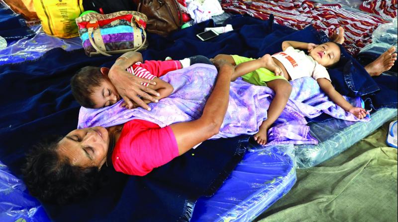 A woman rescued by the Navy from Kalady rests along with her grandchildren at the Naval relief camp in Kochi.  (Photo: ARUN CHANDRABOSE)