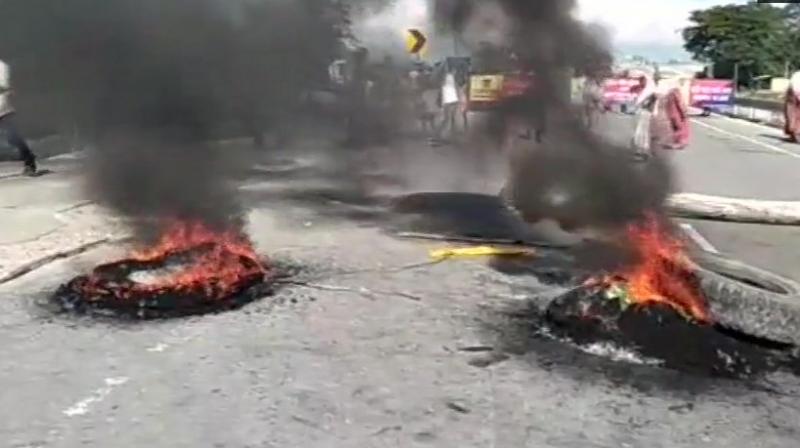 Women block Dhola-Tinsukia highway and burn tyres in protest against murder of 5 people by terrorists in Bishnoimukh village in Tinsukia. (Photo: Twitter | ANI)