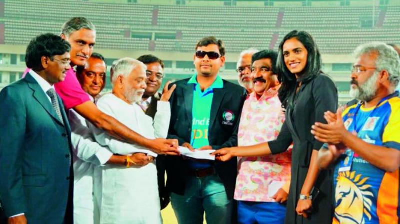 Mahender Vaishnav (centre), member of Indias World Cup winning blind cricket team, is presented a cheque for 10 lakh by team owners of the Telangana T20 League at the final presenation ceremony at Rajiv Gandhi International Cricket Stadium in Hyderabad on Sunday night. Also seen in the picture are Rajya Sabha member K. Keshav Rao (left) and shuttler P. V. Sindhu.