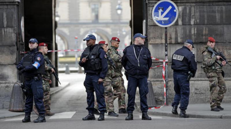 Police officers cordon off the area near the Louvre museum near where a soldier opened fire after he was attacked in Paris. (Photo: AP)