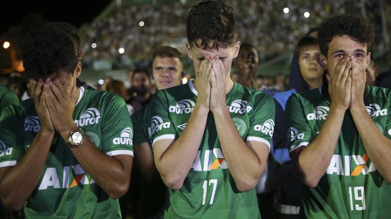 Players mourn during a tribute to the crash victims at Arena Condado stadium in Chapeco, Brazil (Photo: AP)