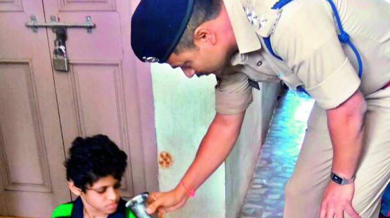 ACP Chaitanya Kumar offers a glass of water to the boy outside his home.