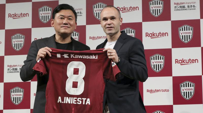 Iniesta, who lifted 32 major trophies and made 674 appearances for Catalan giants Barca, is handed his trademark number eight shirt by Vissel owner Hiroshi Mikitani. (Photo: AP)