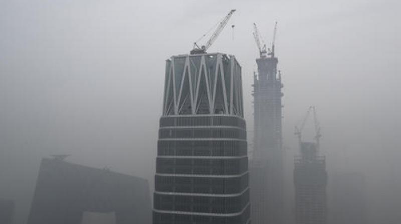 Chinas state broadcaster China Central Television (CCTV) headquarters and construction buildings at the Central Business District are shrouded by heavy smog in Beijing. (Photo: AP)