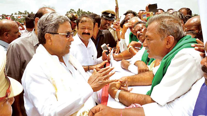Chief Minister Siddaramaiah interacts with farmers during his visit to Mandya to launch various developmental works on Friday
