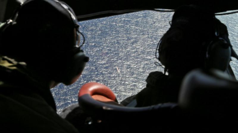 Crew members looking out the cockpit windows of a RNZAF P3 Orion during search operations for wreckage and debris of missing Malaysia Airlines Flight MH370 in the southern Indian Ocean (Photo: AFP)