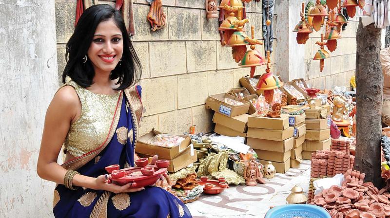 Model and student Thrupthi Neelamma supports local artisans by buying clay diyas in the city in the specially shot photograph