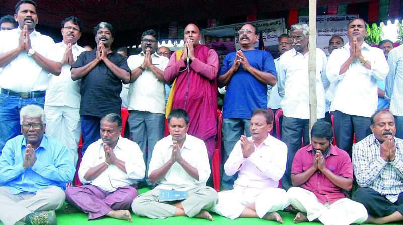 Buddhist monks under the aegis of JAC of Buddhist Organisations stage a protest opposing the allotment of 15 acres for construction of Film Nagar Centre at Buddhist Monument site, Thotlakonda outside the district collectorate in Vizag on Friday. (Photo: DC)