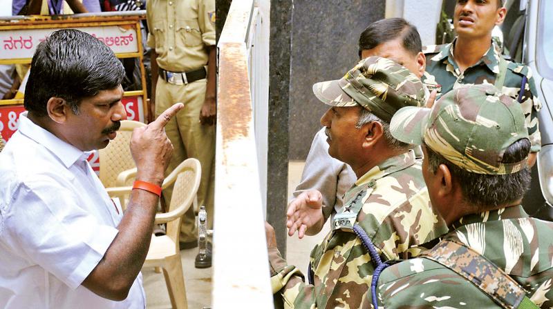 MP D.K. Suresh argues with security personnel in front of his brother D.K. Shivakumars house in Bengaluru on Friday