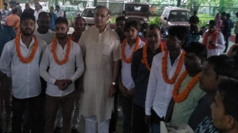 Union Minister of State for Civil Aviation Jayant Sinha is seen with the convicts at his residence after they were released on bail.