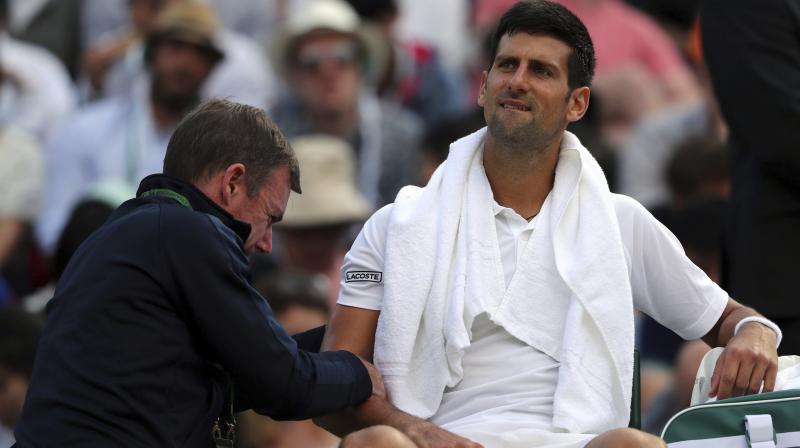 Novak Djokovic receives medical treatment during his Mens Singles Match against Czech Republics Tomas Berdych on day nine of the Wimbledon Tennis Championships. (Photo: AP)