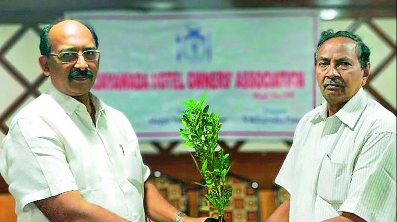 Commercial department officials distribute saplings to owners of shops in Vijayawada on Saturday. (Photo: DC)