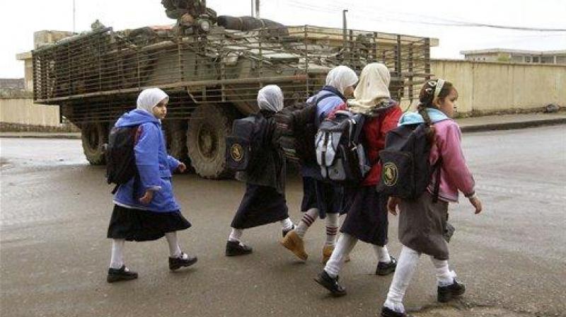In this file photo, Iraqi girls walk past a US Army Stryker combat vehicle on their way home from school in Mosul, Iraq. (Photo: AP)