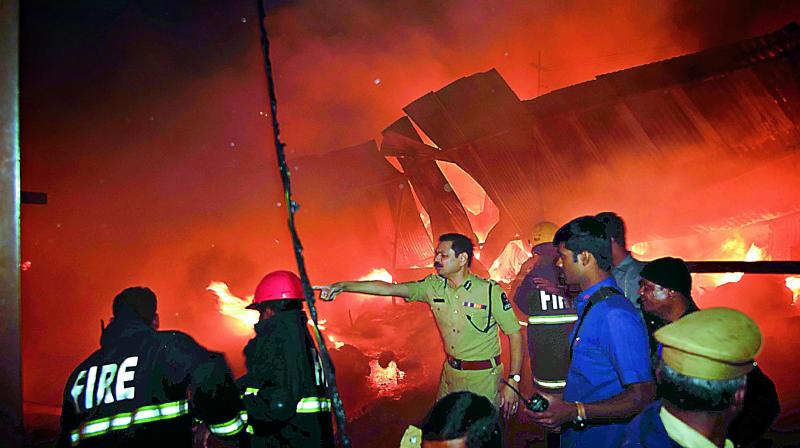 Fire fighters and police personnel try to control the massive blaze at the Exhibition Grounds hosting the All India Industrial Exhibition on Wednesday.  (P. Anil Kumar)