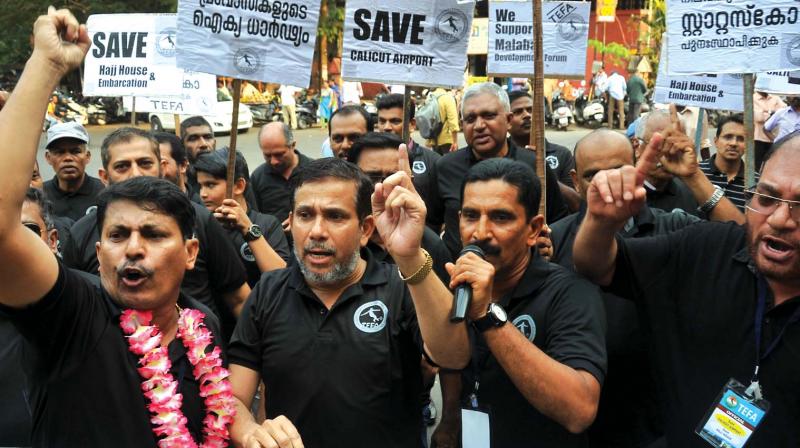 Men shout slogans marking the end of a day and night agitation demanding reinstating the embarkation status to Calicut airport in Kozhikode on Saturday. (Photo:  DC)