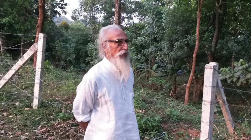 Paris Mohan Kumar in front of his land encroached by a real estate group at Niravilpuzha, Wayanad on Saturday. (Photo: DC)