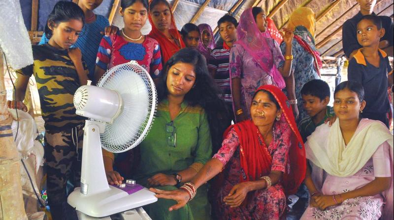 Vrinda Mohan (in Green dress) operates the solar fan she contributed to the Rajasthani families in Pookad near Koyilandy on Saturday.  	(Photo: Venugopal)