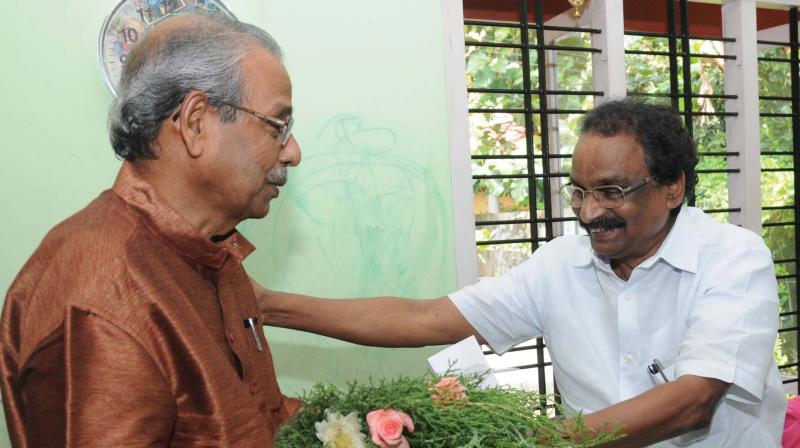 Culture and law minister A.K. Balan felicitates writer C. Radhakrishnan while conveying the message that he has been selected for this years Ezhuthachan Puraskaram.