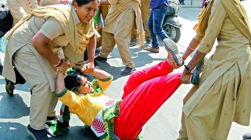 Students protesting at RTC Crossroads are taken into custody by police on Wednesday.  (Photo: DC)