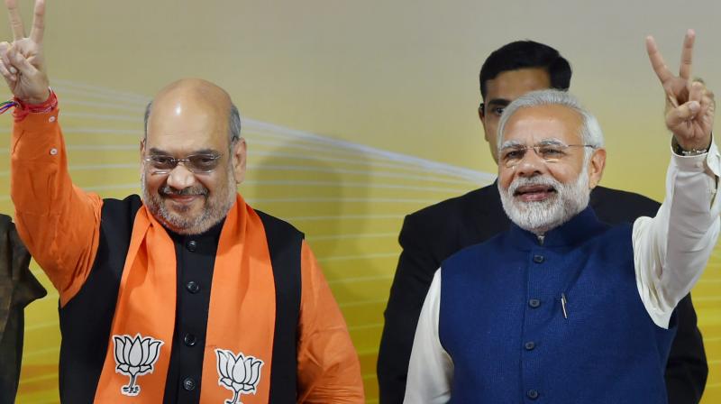 Prime Minister Narendra Modi and BJP President Amit Shah flash victory sign at a felicitation function before the partys parliamentary board meeting in New Delhi on Monday, after the partys win in Gujarat and Himachal Pradesh Assembly elections. (Photo: PTI)