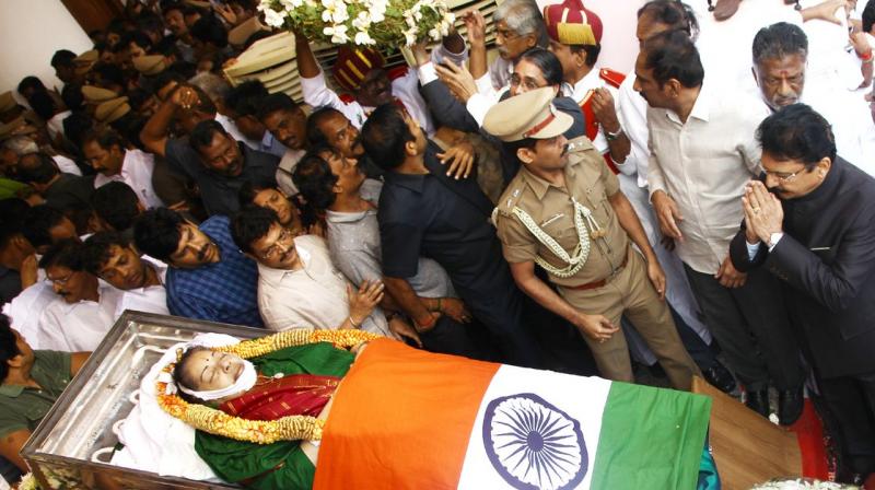 Politicians and friends surround the body of Jayalalithaa, who was dressed in green for her final journey. (Photo: Twitter)