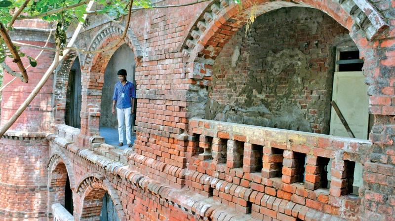 A staffer inspecting the gap in the wall that collapsed at  Victoria Mens Hostel, in Chepauk.