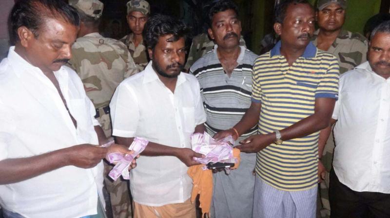 Residents display cash seized by police ahead of RK Nagar byelection on Wednesday. Residents and party workers were later detained by poll officials for inquiry (Photo: DC)